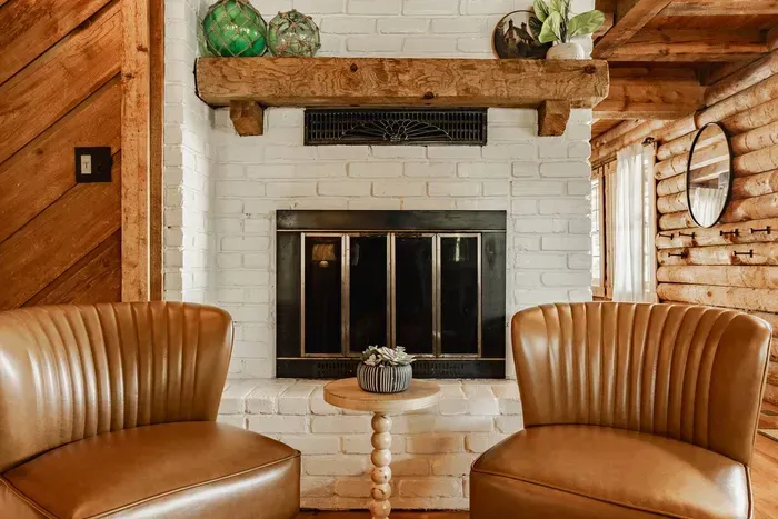 Fireplace nook with leather chairs and rustic charm.