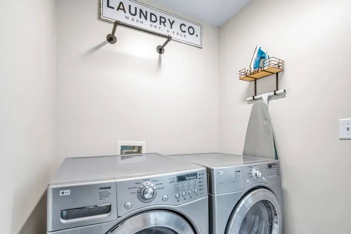Convenient in-home laundry area equipped with a washer and dryer, a flat iron and an ironing board.