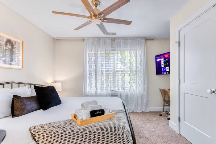 Showcasing an elegant monochrome décor, and large windows with airy curtains that fill the room with natural light