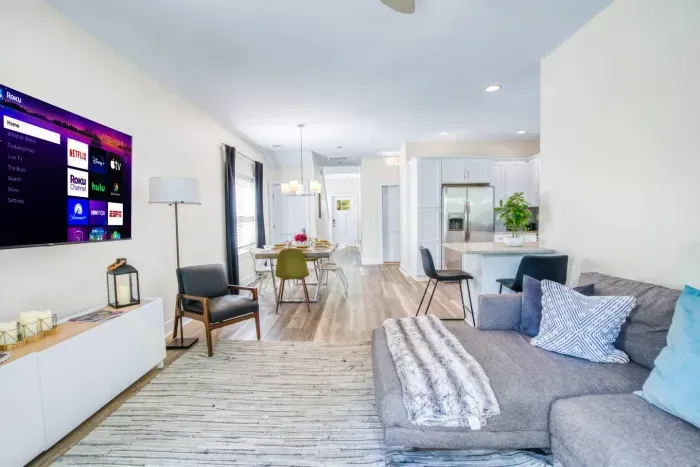 Open-concept living area with modern décor, smart TV, and seamless flow to dining and kitchen spaces.