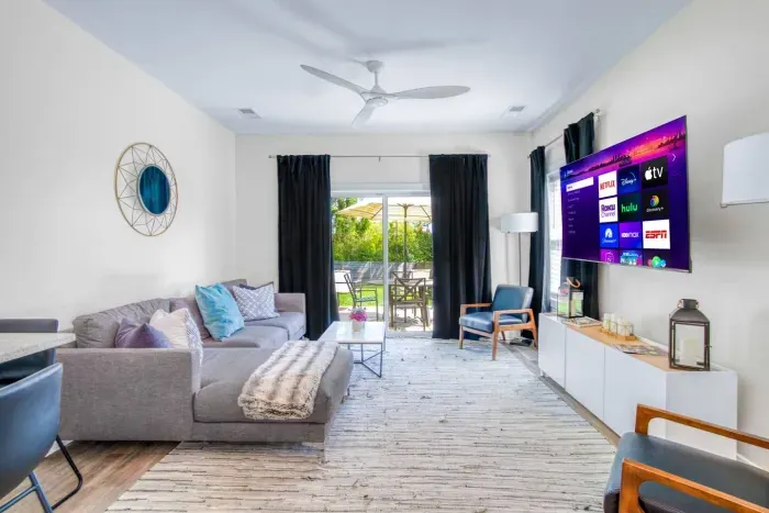 Bright and modern living room with cozy seating, smart TV, and patio access for relaxing indoor-outdoor living.