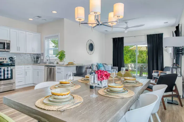 Bright open-concept layout with a modern kitchen, dining area, and living space leading to the patio.