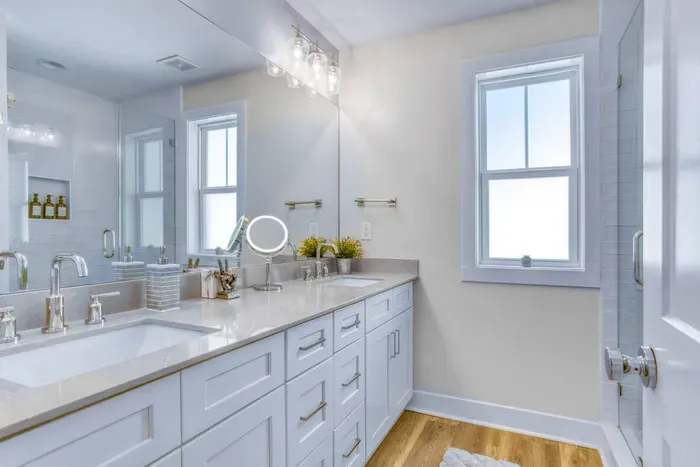 Bright and modern bathroom with double vanity, large mirror, and natural light — perfect for a refreshing start to your day.