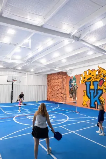 Private indoor pickleball/basketball court with vibrant mural and lighting