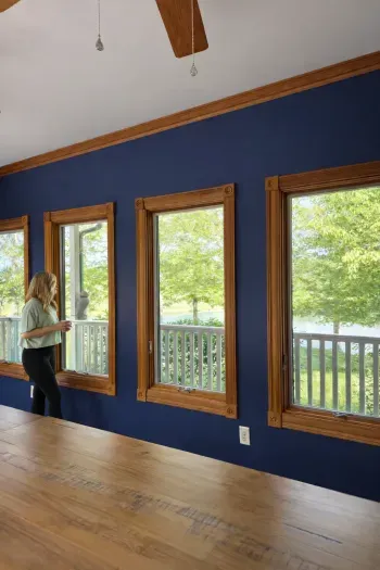 Bright sunroom with lakeview windows, vaulted ceiling, warm wood accents.