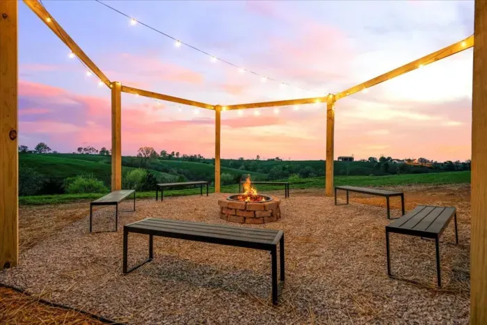 Firepit under a hexagon pergola with solar powered dusk to dawn string lights