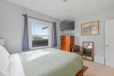 Comfortable bedroom with plush bedding and TV.