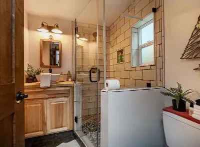 Cool, cabin-y bathroom with a pebble shower floor and cute, rustic decor. We provide plush towels and eco-friendly shower products.