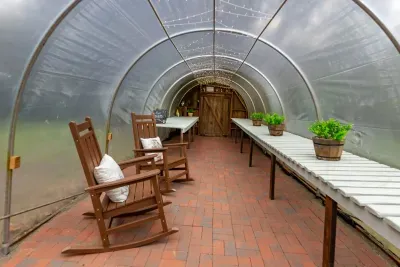 Inside the greenhouse, rocking chairs offer a sheltered place to sit and enjoy a quiet moment.