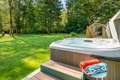 The outdoor hot tub overlooks the lawn and trees—a relaxing spot to unwind after your mountain adventures.