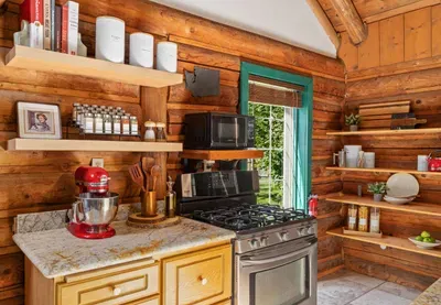 The kitchen’s range, microwave, mixer, and open shelves help make meals at the cabin easy.