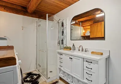The bathroom includes a shower, vanity, mirror, and space to freshen up after a day outdoors.