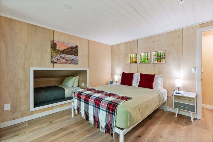 The main bedroom, located upstairs, has a plush queen bed, cozy sleeping nook, and it's own private deck overlooking the river.