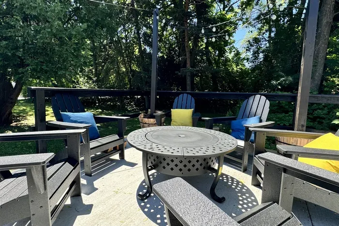 New outdoor fire pit with seating under the string lights at night.