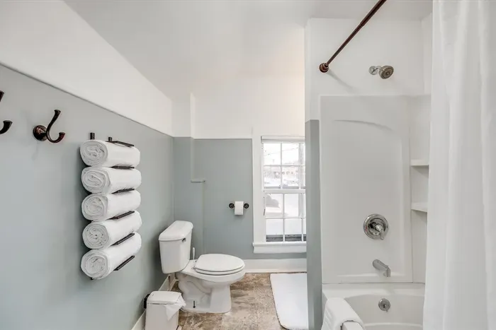 Full bathroom with towels and shower amenities.