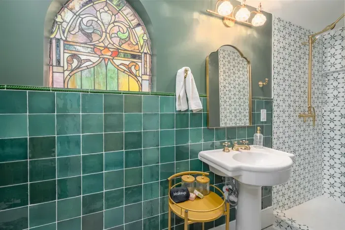Vintage stained glass was preserved in the bathroom remodel