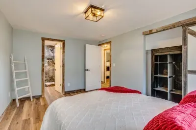 Master bedroom leading into the master bathroom: Queen Tempurpedic Mattress. The closet has hangers, two luggage racks, a wardrobe, a fan, a laundry basket, an iron, and an ironing board. A throw blanket and 2 throw pillows are in each bedroom.
