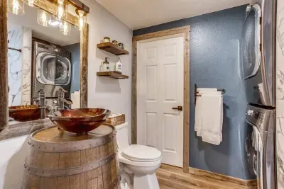 Downstairs full bathroom with washer and dryer: Includes laundry detergent and dry sheets. Custom-made whiskey barrel vanity. Custom-built open shelves with extra toiletries provided on the shelves. For a list of the extras provided, keep scrolling.