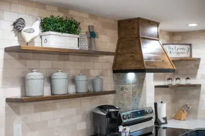 Kitchen: handcrafted range hood, open shelves. Provided coffee, tea, and hot cocoa Keurig pods. Oven, Keurig, and more! Beautiful farmhouse decor. Vestige Natural Tile behind the oven and then counter to ceiling Botticino Marble Tile.