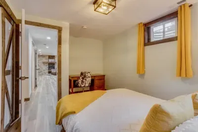Cheery bedroom and office- behind the secret door: Every bedroom has a closet with hangers and a luggage rack. Each room also has its own throw blanket and pillows. There is a desk and cow print chair for a little at-home office space in this room.