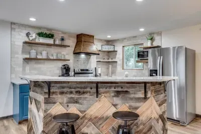 Hand-crafted range hood, open shelves, and kitchen island. Provided coffee, tea, and hot cocoa Keurig pods. Oven, dishwasher, microwave, full-sized refrigerator, Keurig, sink, cooking utensils,  pots & pans, baking sheet, and more!
