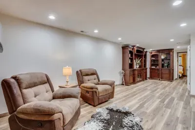 Fireplace room with the secret sliding bookcase. Two reclining chairs next to the electric fireplace. Books and games are located in the bookshelf.