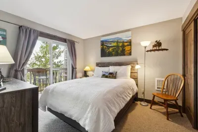 Snuggle in under the mountain skies. This bedroom features balcony access, soft lighting, and lodge-style touches that make you feel right at home in the Rockies.