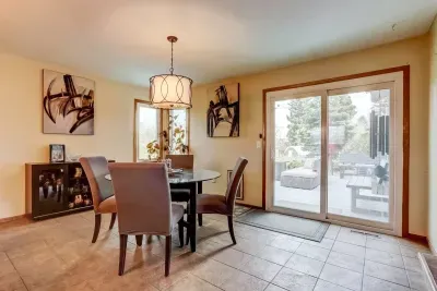 Dining room with glass sliding door into the backyard. Seating for 4 people. dimmable light fixture. Decor table center piece and salt/pepper.