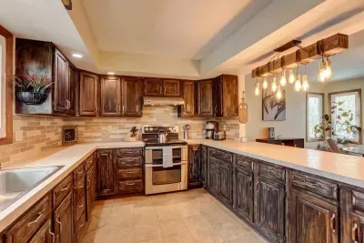 Custom-cabinets and kitchen island. Provided coffee, tea, and hot cocoa. Oven, dishwasher, microwave, full-sized refrigerator, coffee maker, kettle, sink, cooking utensils,  pots & pans, baking sheet, and more!