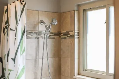 Rinse and refresh under our modern showerhead! Natural light and sleek tile details make every shower a little more luxurious. 🚿✨