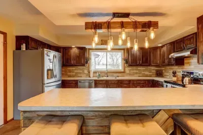 Rustic charm meets modern comfort! 🌟 Cook, chat, or sip morning coffee at this inviting kitchen island under warm, glowing lights. 🍽️☕#HomeAwayFromHome