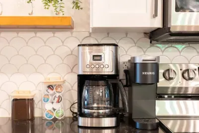 Start your day right with our coffee bar, complete with starter supplies like coffee, filters, Keurig pods, coffee grinder, sugar, and creamer.