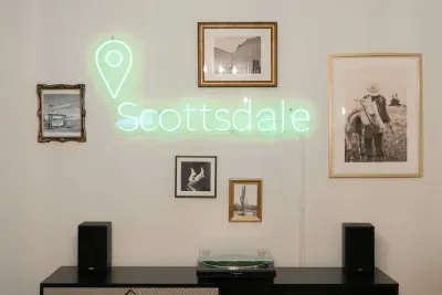 Delight in a space that seamlessly merges modern comfort with Western aesthetics, showcased by a wall illuminated by a stylish sign and vintage photographs.