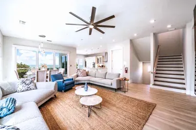 Relax in this spacious, light-filled living area featuring plush seating, modern décor, and an open layout. Perfect for gathering with family or friends, it offers comfort, style, and easy flow throughout your beautiful coastal retreat!
