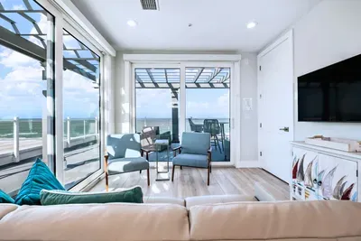 Enjoy seamless indoor-outdoor living in this bright coastal lounge with ocean views, stylish seating, and direct access to the balcony. Relax, unwind, and soak in the fresh sea breeze from this stunning and inviting retreat!