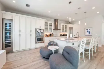 Cook and gather in this stunning chef’s kitchen with sleek white cabinetry, spacious island seating, and high-end appliances. Bright, open, and beautifully designed, it’s perfect for entertaining, casual meals, and creating lasting memories!