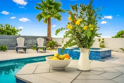 A vibrant outdoor setting with lush plants and poolside seating makes this space feel like a private resort.