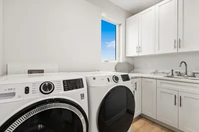 Convenient in-home laundry room with modern washer and dryer, ample storage, and countertop space for easy vacation living.
