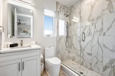 Enjoy a private ensuite with elegant marble finishes, a glass walk-in shower, and modern vanity for a spa-like experience.