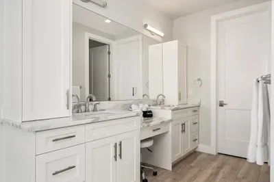 This master bathroom features dual vanities, modern lighting, and plenty of space to get ready in comfort and style.