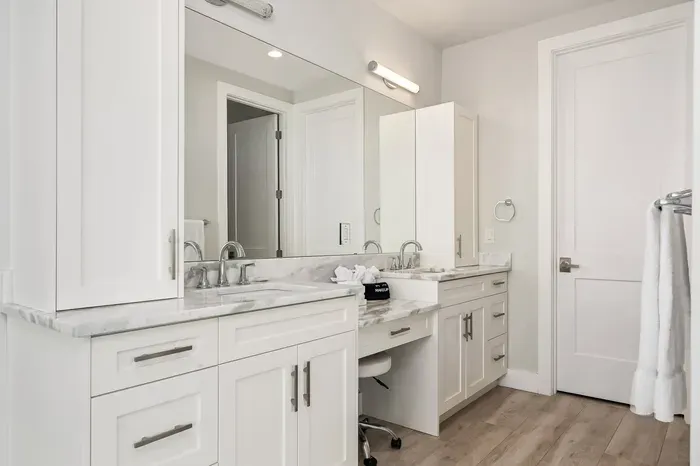 This master bathroom features dual vanities, modern lighting, and plenty of space to get ready in comfort and style.