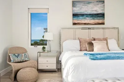 Styled with coastal touches and soothing tones, this serene bedroom offers comfort and charm with the sea just outside your window.