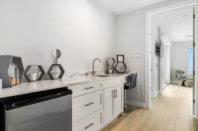 A chic wet bar with sink and counter space makes it easy to mix drinks or prepare quick refreshments without leaving the living area.