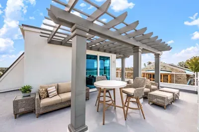 Enjoy elevated outdoor living on this spacious rooftop terrace with comfortable seating, dining space, and a shaded pergola. Perfect for sunset gatherings, morning coffee, or relaxing under the open sky with refreshing coastal breezes!