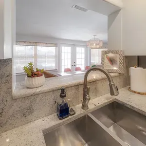 Kitchen with pass through view of dining room and french doors leading to pool