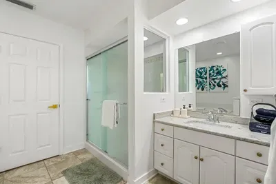 Primary bathroom with shower, jacuzzi tub, and two vanities.