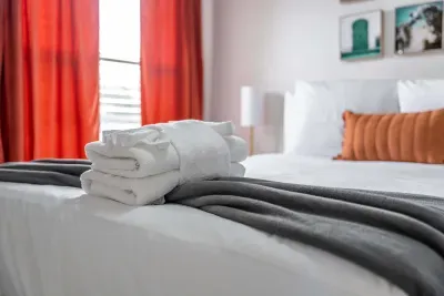 A beautifully appointed bedroom featuring a plush queen-sized bed dressed in crisp white linens, complemented by a cozy grey throw.