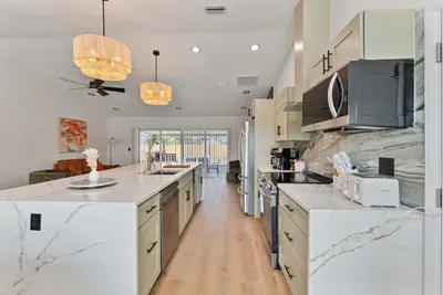 This wide-angle shot highlights the expansive kitchen island, designed for both cooking and casual dining. With ample room for meal preparation, it serves as the heart of the home, surrounded by modern appliances.