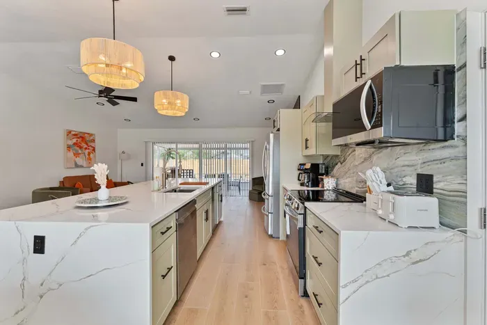 This wide-angle shot highlights the expansive kitchen island, designed for both cooking and casual dining. With ample room for meal preparation, it serves as the heart of the home, surrounded by modern appliances.