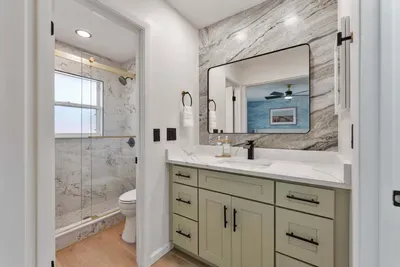 A sleek bathroom corner featuring elegant bottles labeled for body wash, shampoo, and conditioner, all neatly arranged on a wooden tray the minimalist design and clean lines enhance the soothing atmosphere, making it easy to enjoy a rejuvenating show